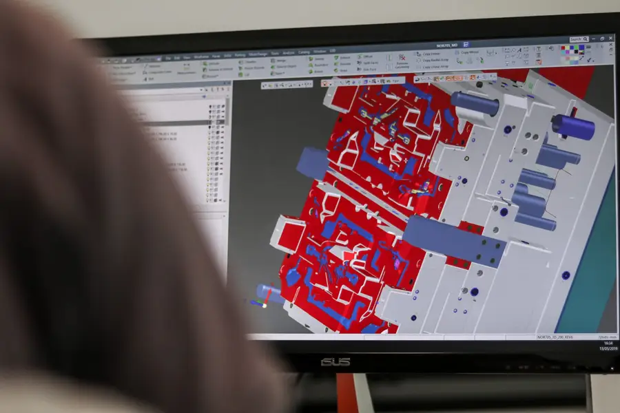 Vista inclinada de uma placa de molde em 3D com extratores e componentes normalizados