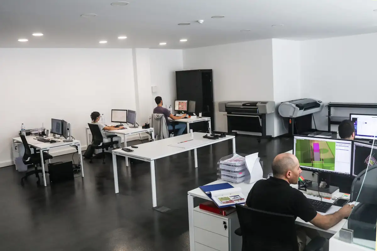 Gabinete da Jorge Cadete visto do lado oposto, com dois plotters de grande formato e um projetista em primeiro plano